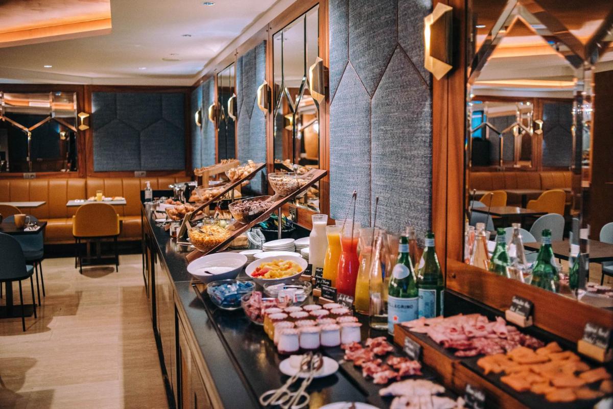 une ligne de buffet avec de la nourriture et des boissons dans un restaurant dans l'établissement Hotel Eiffel Blomet, à Paris