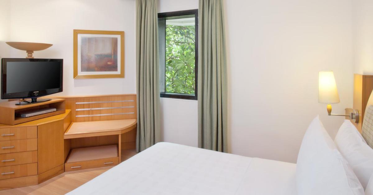 a hotel room with a bed and a television at Trident Chennai in Chennai