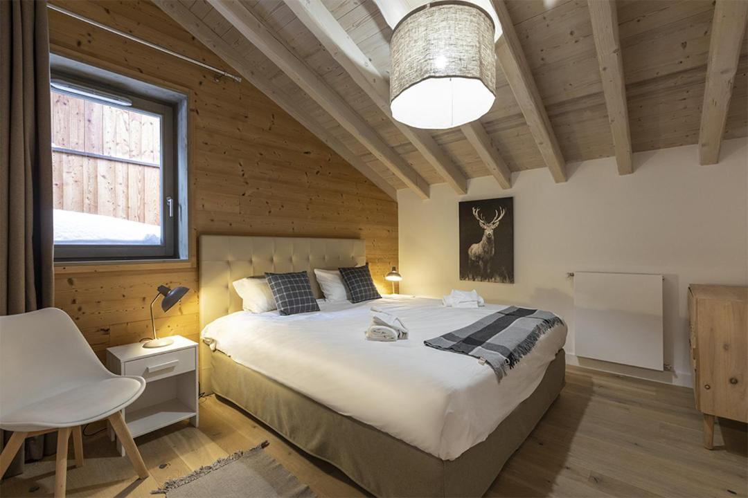 une chambre avec un grand lit et une fenêtre dans l'établissement TERRESENS - Le Hameau de Barthélémy, à La Rosière