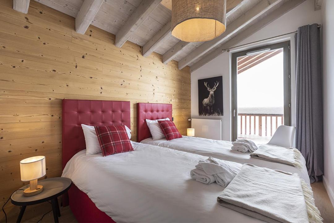 - 2 lits dans une chambre avec un mur en bois dans l'établissement TERRESENS - Le Hameau de Barthélémy, à La Rosière