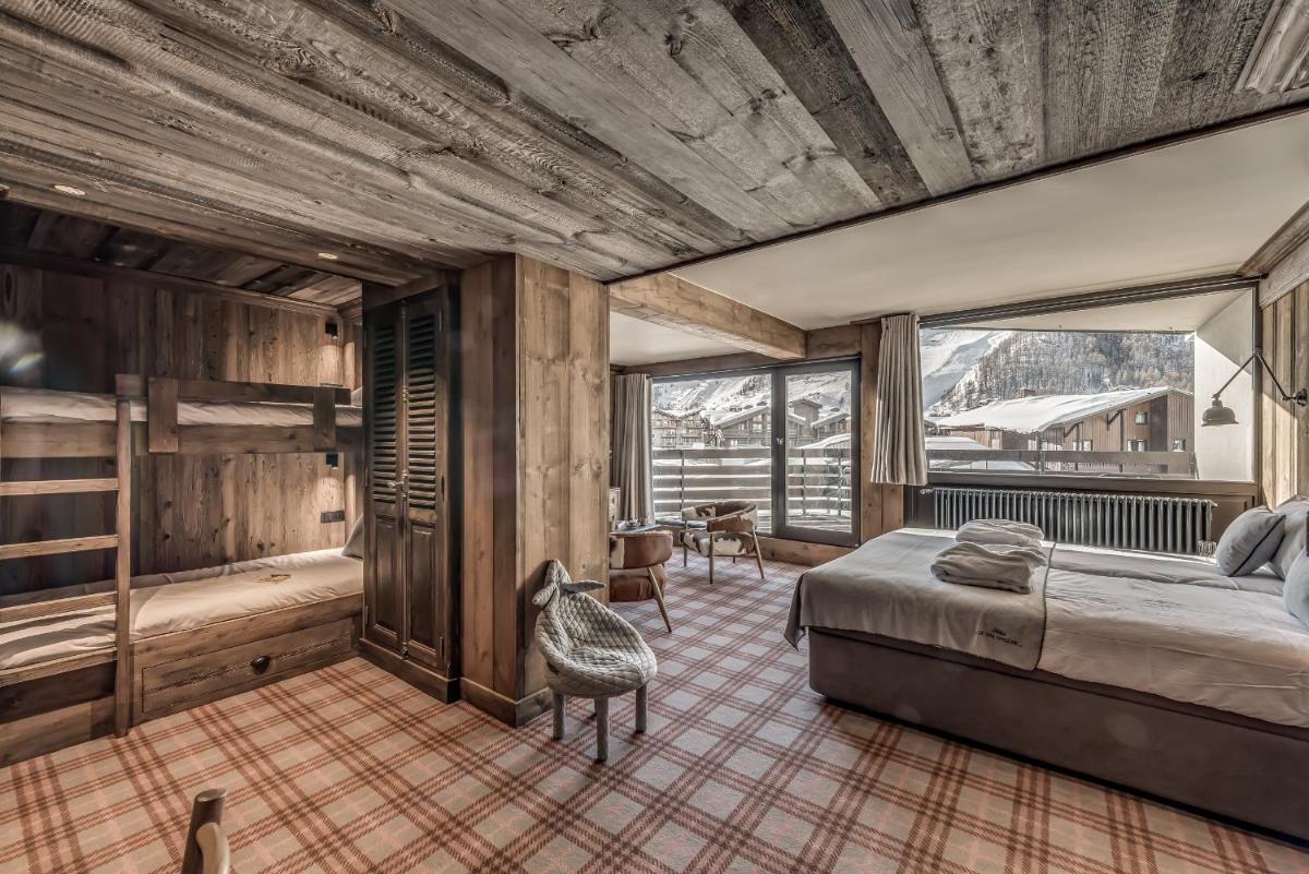 une chambre avec un lit, une table et des chaises dans l'établissement Hotel & Spa Le Val d'Isère, à Val dʼIsère 276 autres photos