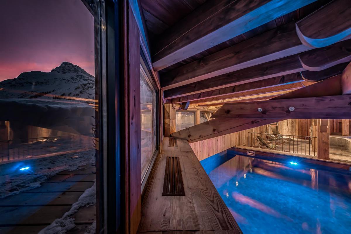 une maison avec piscine la nuit dans l'établissement Hotel & Spa Le Val d'Isère, à Val dʼIsère