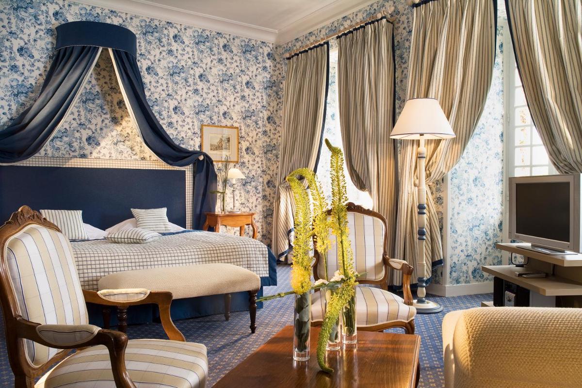une chambre d'hôtel avec un lit et une télévision dans l'établissement Château De Villiers-Le-Mahieu, à Villiers-le-Mahieu