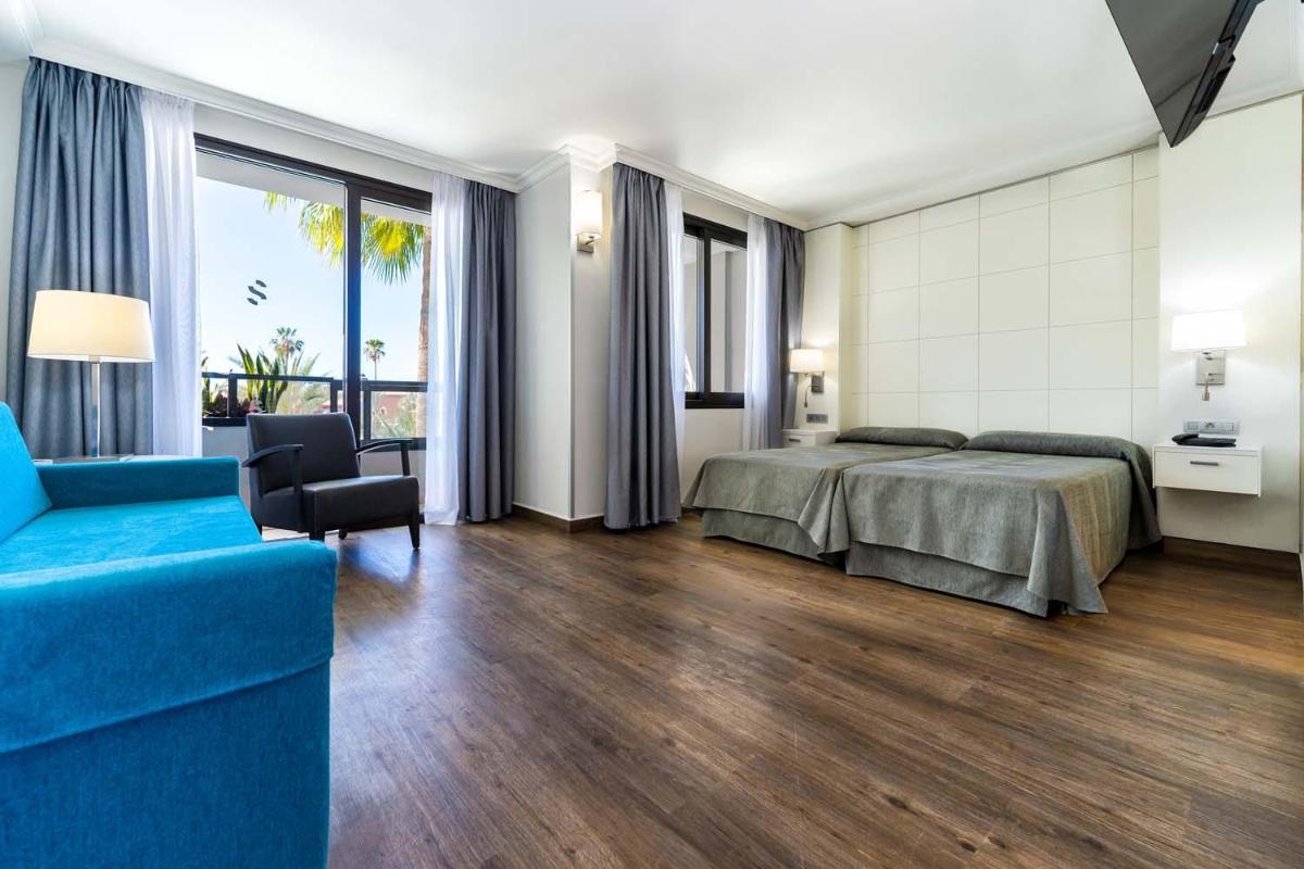 Una habitación de hotel con una cama y un sofá azul. en Spring Hotel Bitácora, en Playa de las Américas 127 fotos más