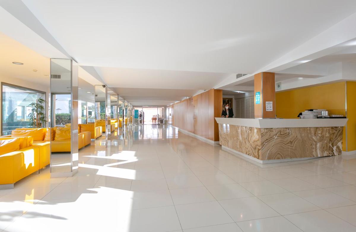 un vestíbulo de un hospital con sillas amarillas y un mostrador en JS Cape Colom - Adults Only, en Portocolom 89 fotos más