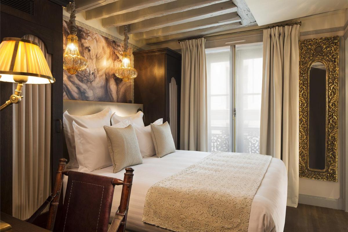 une chambre avec un grand lit avec des oreillers blancs dans l'établissement Hôtel Da Vinci & Spa, à Paris