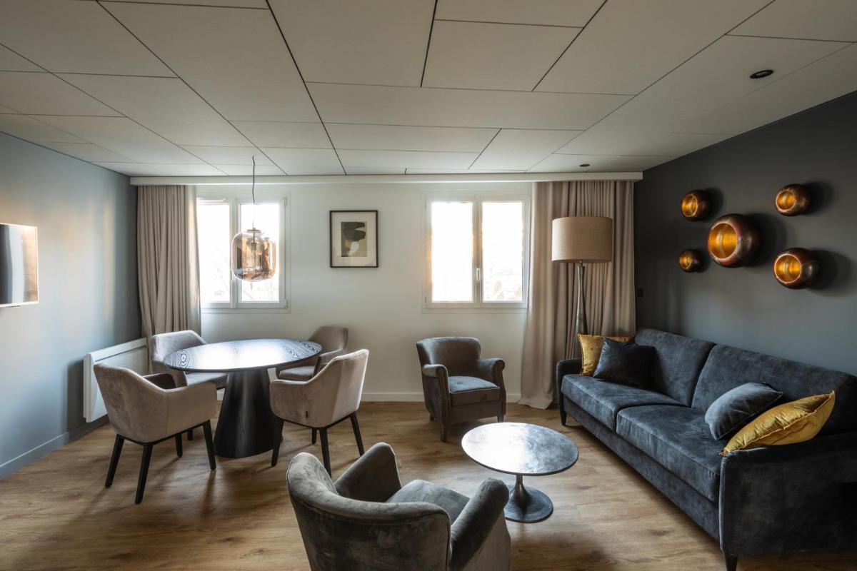 un salon avec un canapé, des tables et des chaises dans l'établissement Edgar Hôtel & Spa - Table Gastronomique, à Saint-Brieuc