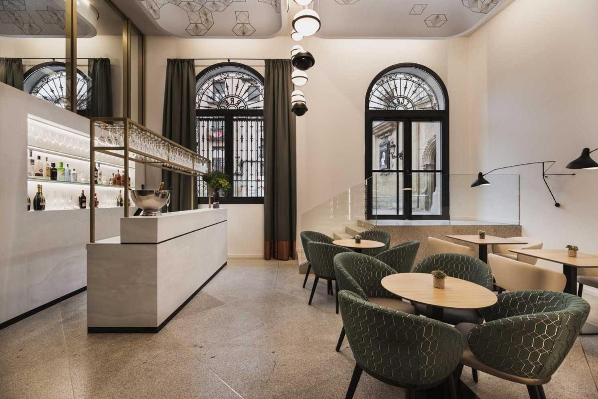 Un restaurante con mesas, sillas y ventanas. en Áurea Palacio de Correos by Eurostars Hotel Company, en Logroño