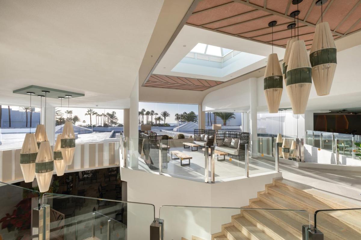 Una sala de estar con escalera y un comedor. en Hotel Riu Paraiso Lanzarote - All Inclusive, en Puerto del Carmen