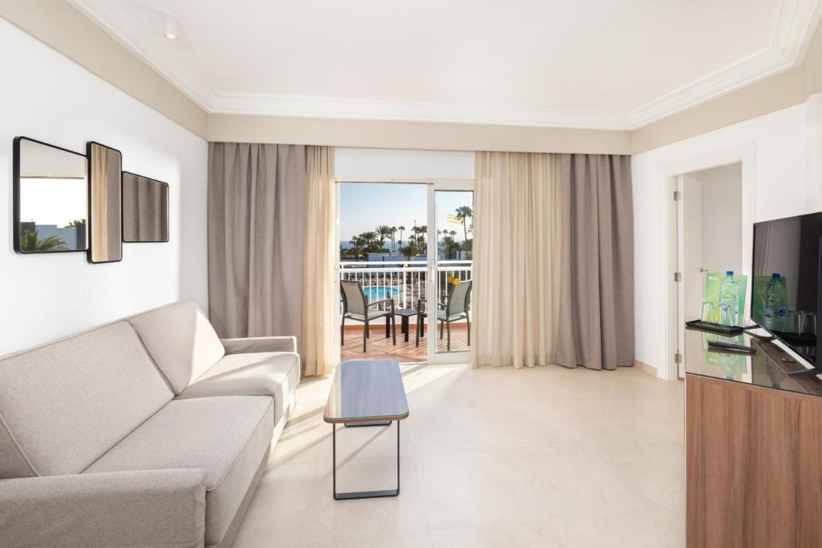 Una televisión o centro de entretenimiento en Hotel Riu Paraiso Lanzarote - All Inclusive