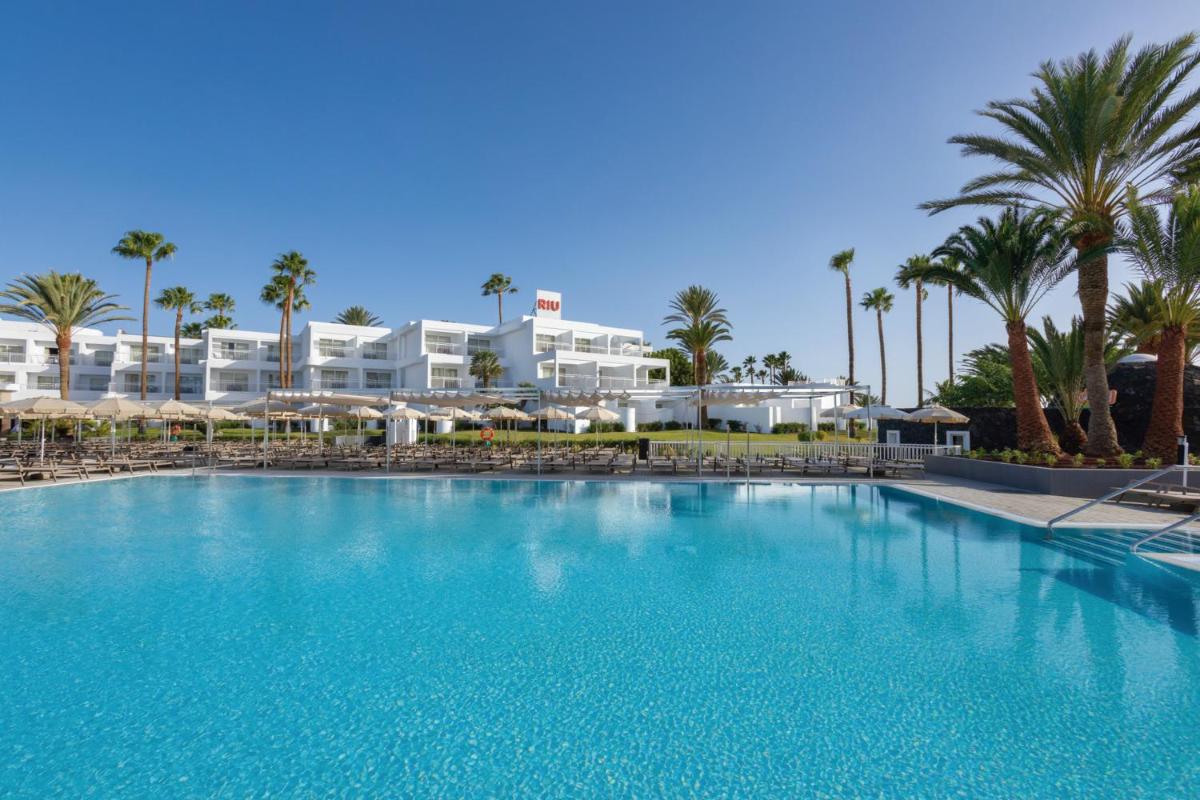 una gran piscina frente a un resort en Hotel Riu Paraiso Lanzarote - All Inclusive, en Puerto del Carmen