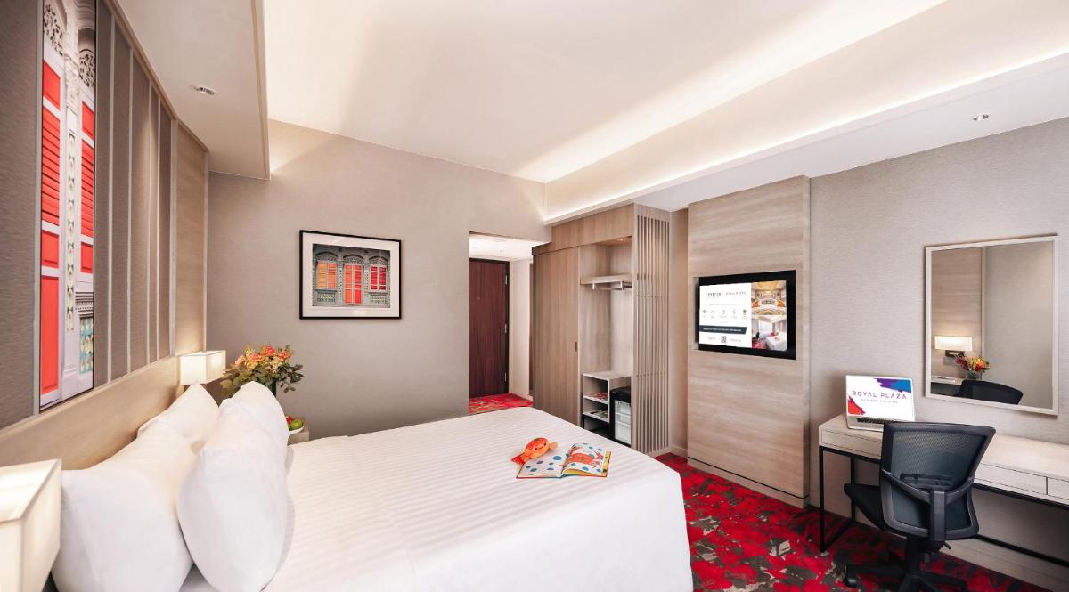 a hotel room with a bed and a desk at Royal Plaza on Scotts in Singapore