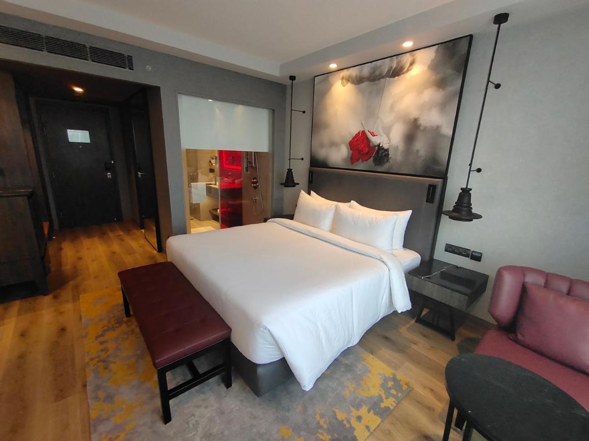 a bedroom with a large white bed and a couch at Radisson RED Chandigarh Mohali in Chandīgarh