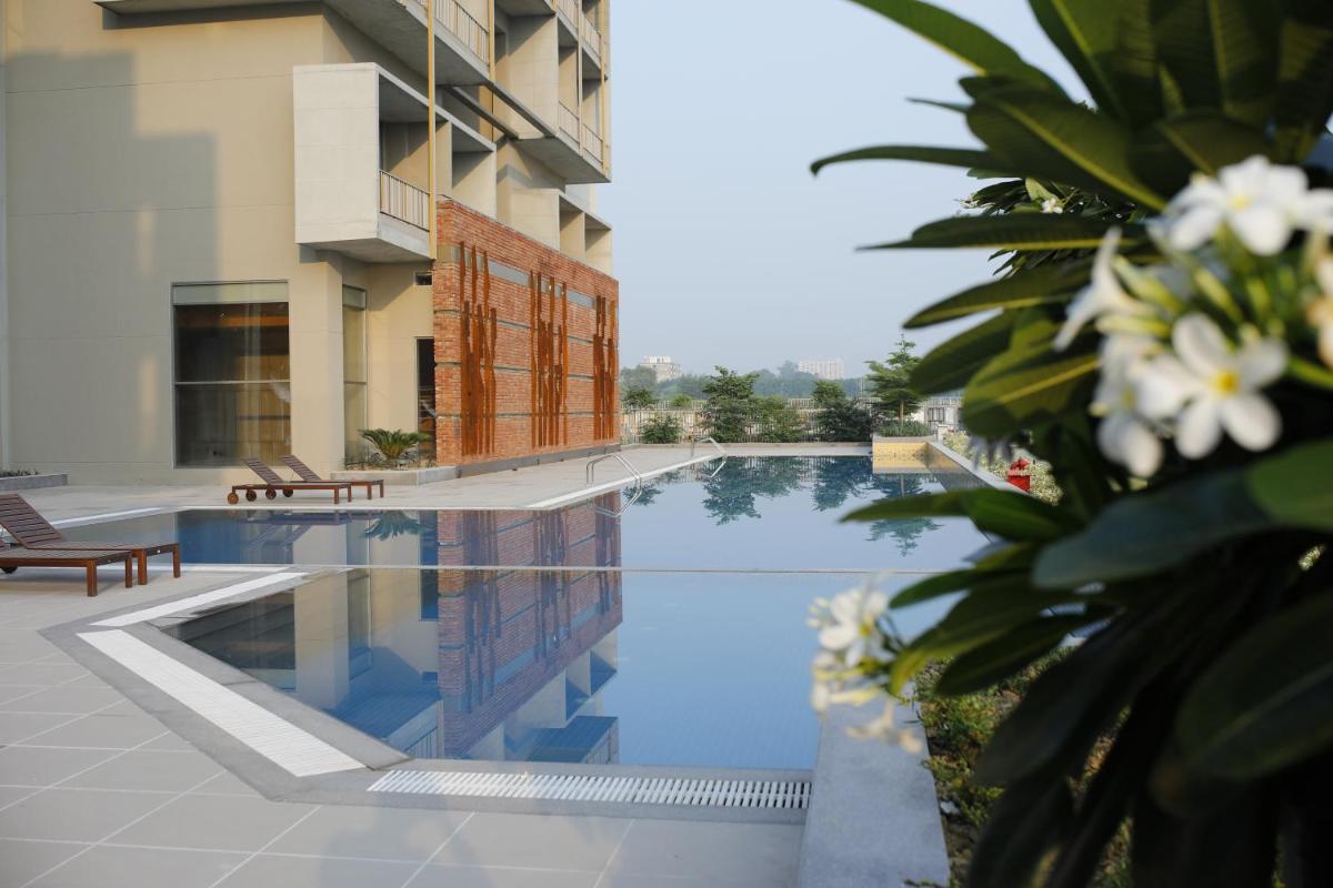 a swimming pool in front of a building at The Centrum in Lucknow