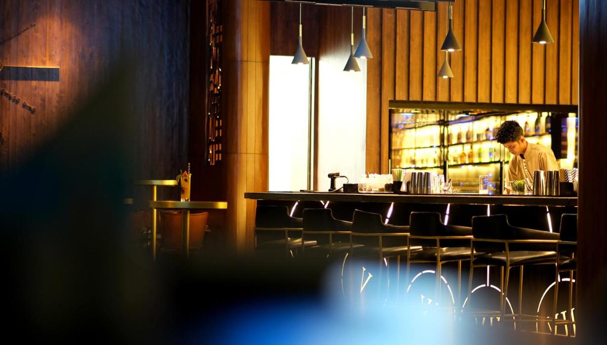 a man standing behind a bar in a restaurant at The Centrum in Lucknow