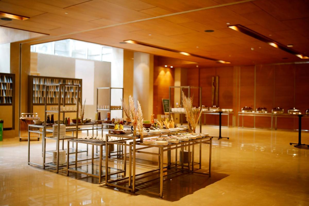 a dining room with tables and chairs in a building at The Centrum in Lucknow