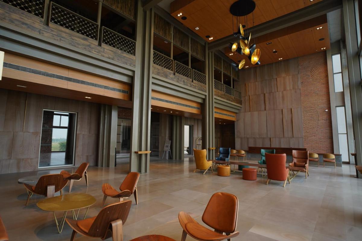 a lobby with tables and chairs in a building at The Centrum in Lucknow
