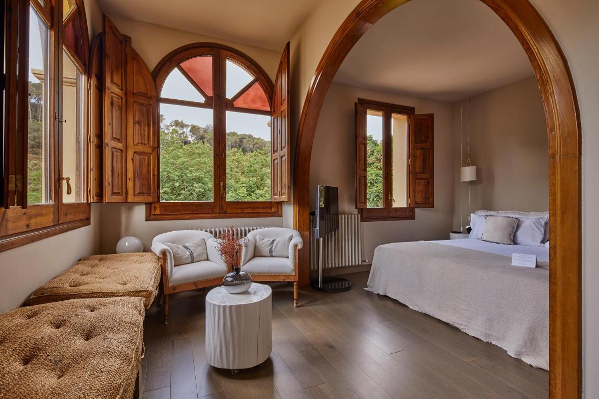Un dormitorio con una cama y un sofá y ventanas. en Mas Salagros EcoResort & SPA, en Vallromanes 75 fotos más