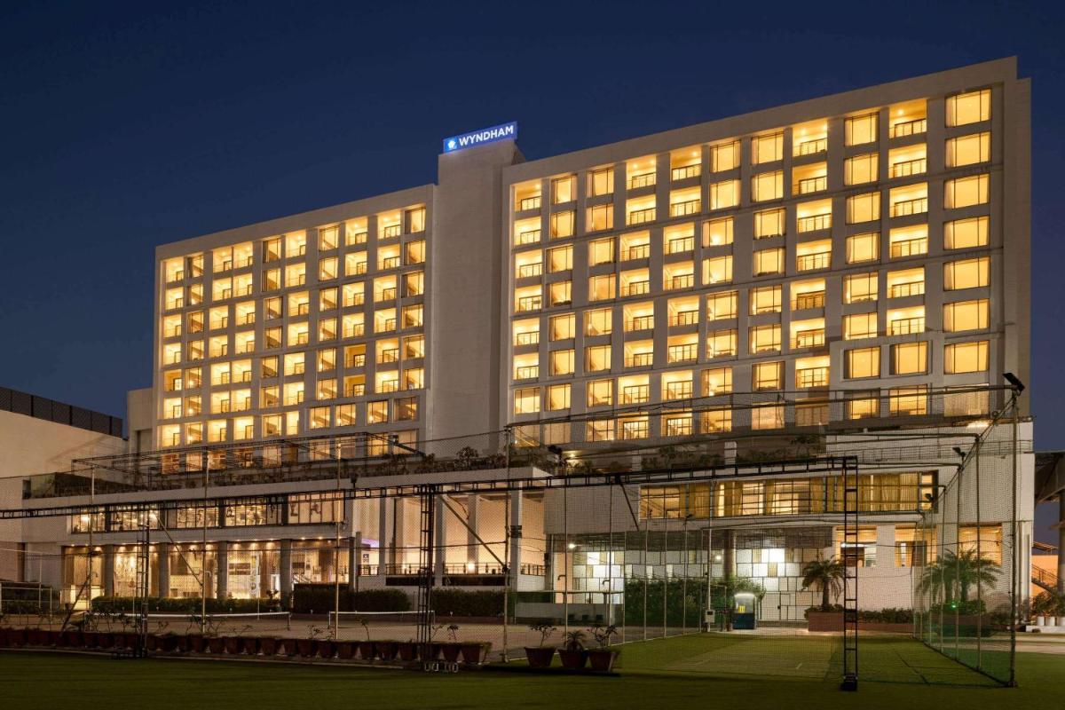 a lit up hotel building at night at Wyndham Ahmedabad Shela in Ahmedabad
