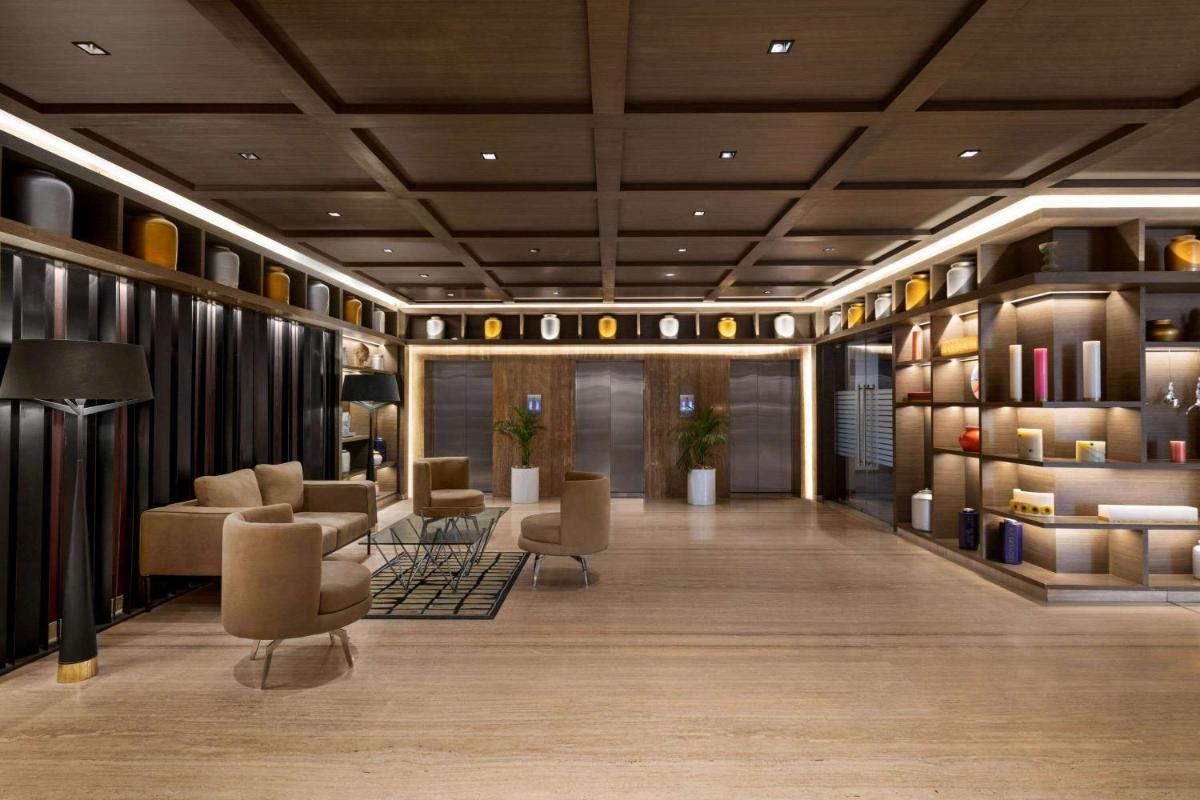 a lobby with couches and chairs in a building at Wyndham Ahmedabad Shela in Ahmedabad