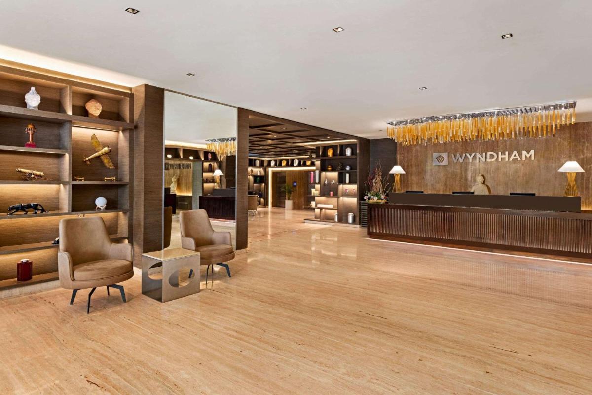 a lobby of a luxury store with chairs and tables at Wyndham Ahmedabad Shela in Ahmedabad