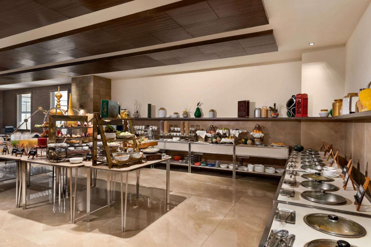 a large kitchen with a lot of food on display at Wyndham Ahmedabad Shela in Ahmedabad