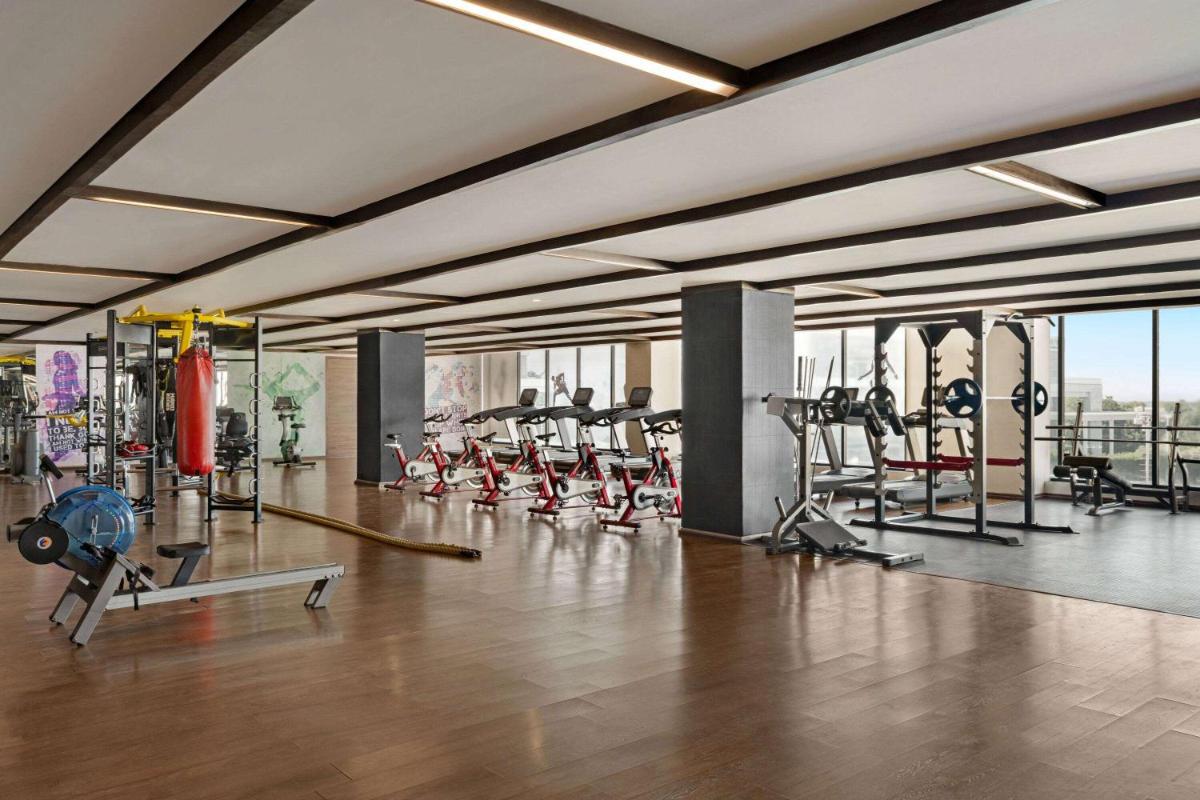 a gym with a lot of treadmills and machines at Wyndham Ahmedabad Shela in Ahmedabad
