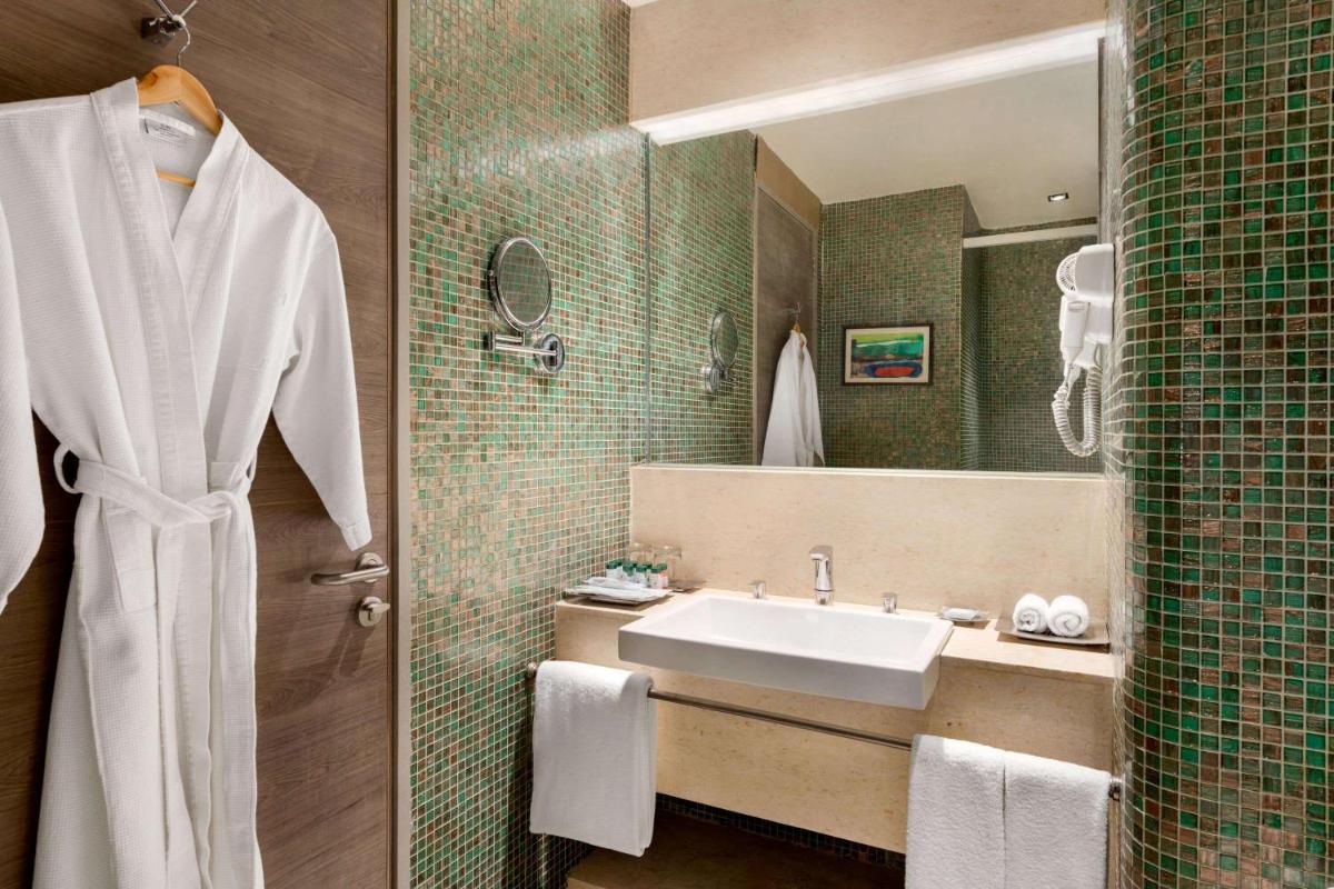 a bathroom with a sink and a mirror at Wyndham Ahmedabad Shela in Ahmedabad