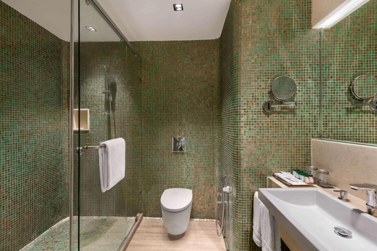 a bathroom with a shower and a toilet and a sink at Wyndham Ahmedabad Shela in Ahmedabad