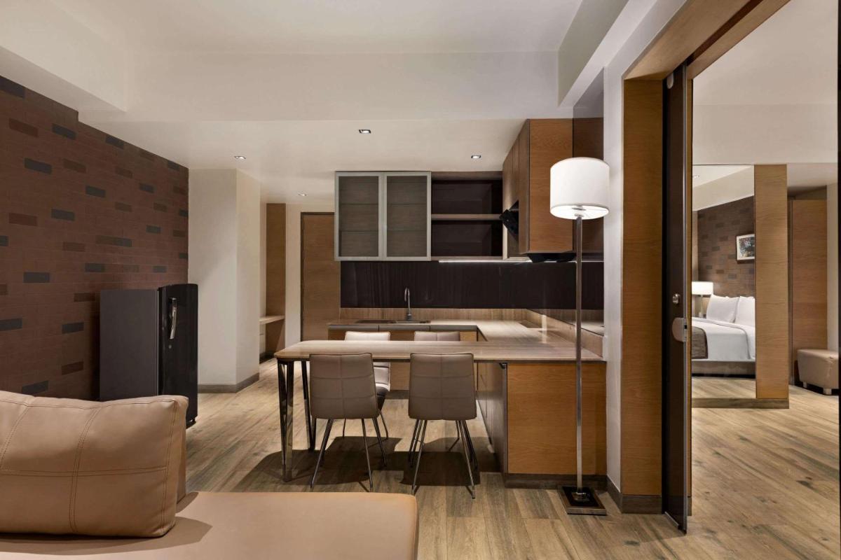 a kitchen and living room with a table and chairs at Wyndham Ahmedabad Shela in Ahmedabad