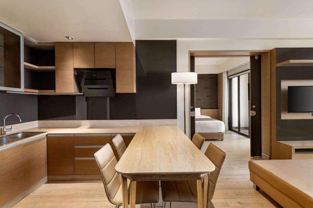 a kitchen and dining room with a table and chairs at Wyndham Ahmedabad Shela in Ahmedabad