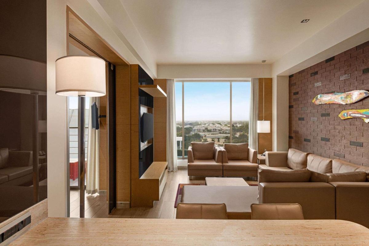 a living room with a couch and a table at Wyndham Ahmedabad Shela in Ahmedabad