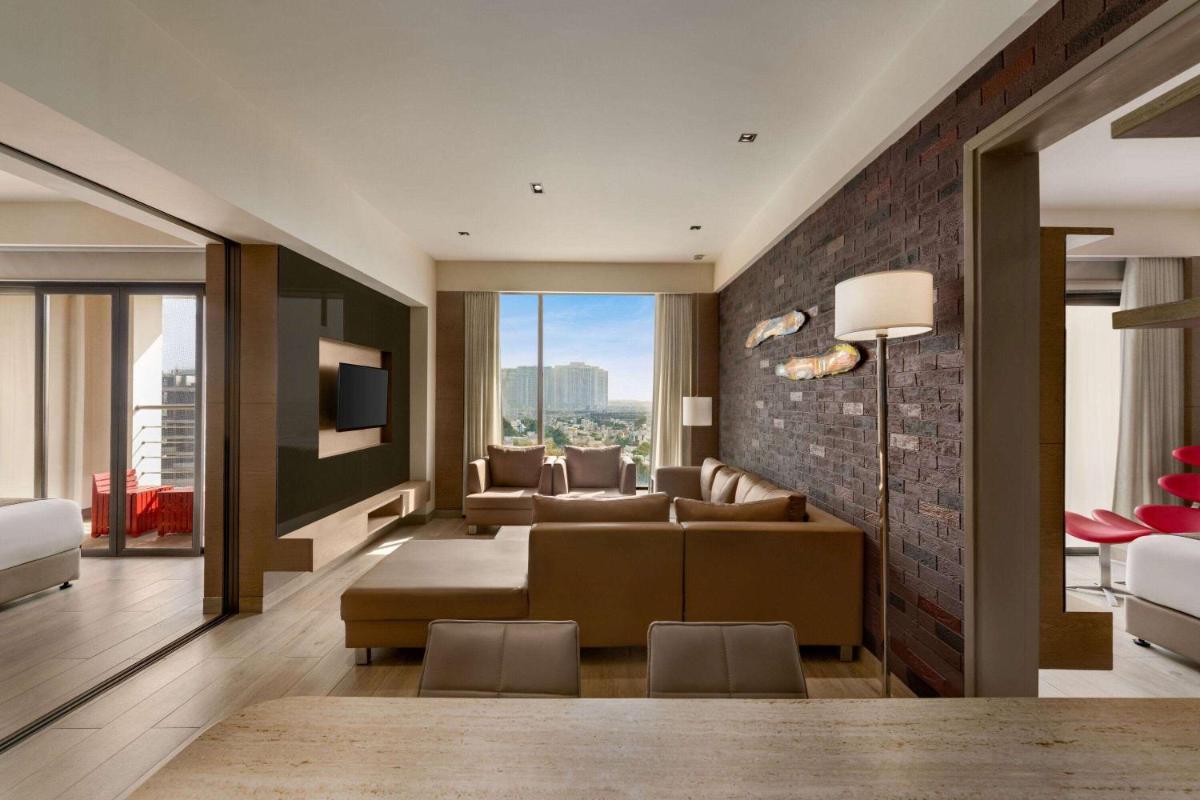 a living room with a couch and a tv at Wyndham Ahmedabad Shela in Ahmedabad
