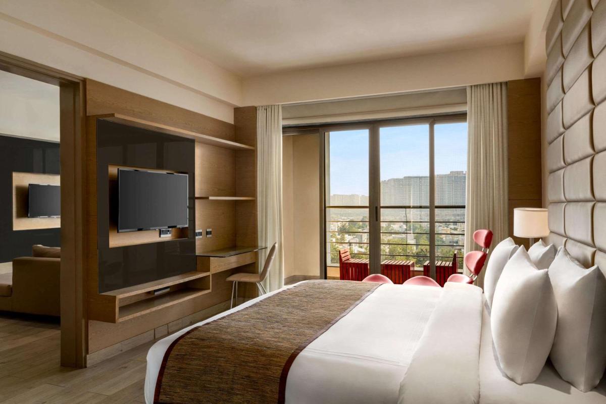 a hotel room with a bed and a television at Wyndham Ahmedabad Shela in Ahmedabad