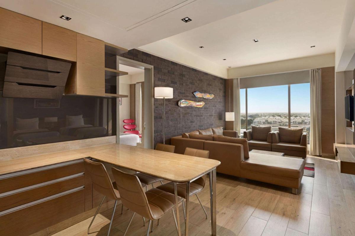 a kitchen and living room with a table and chairs at Wyndham Ahmedabad Shela in Ahmedabad