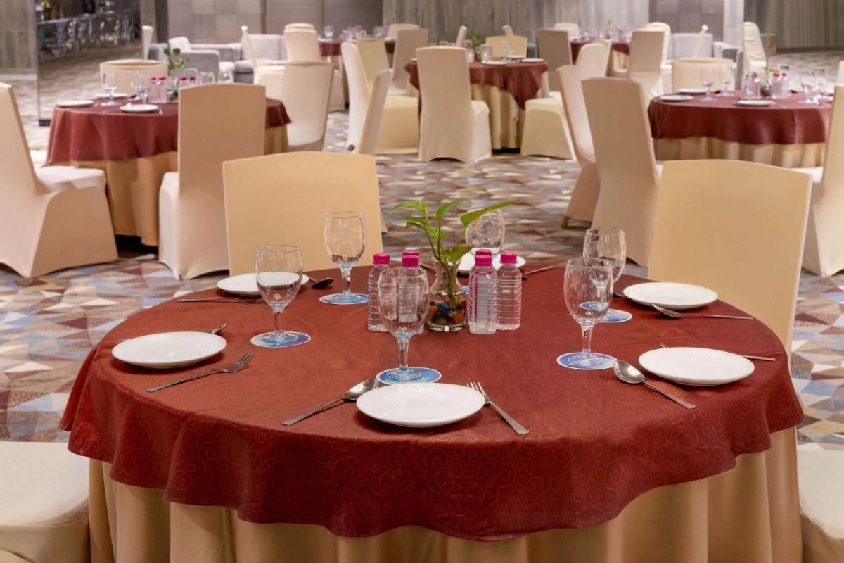 a table with a red table cloth and wine glasses at Wyndham Ahmedabad Shela in Ahmedabad
