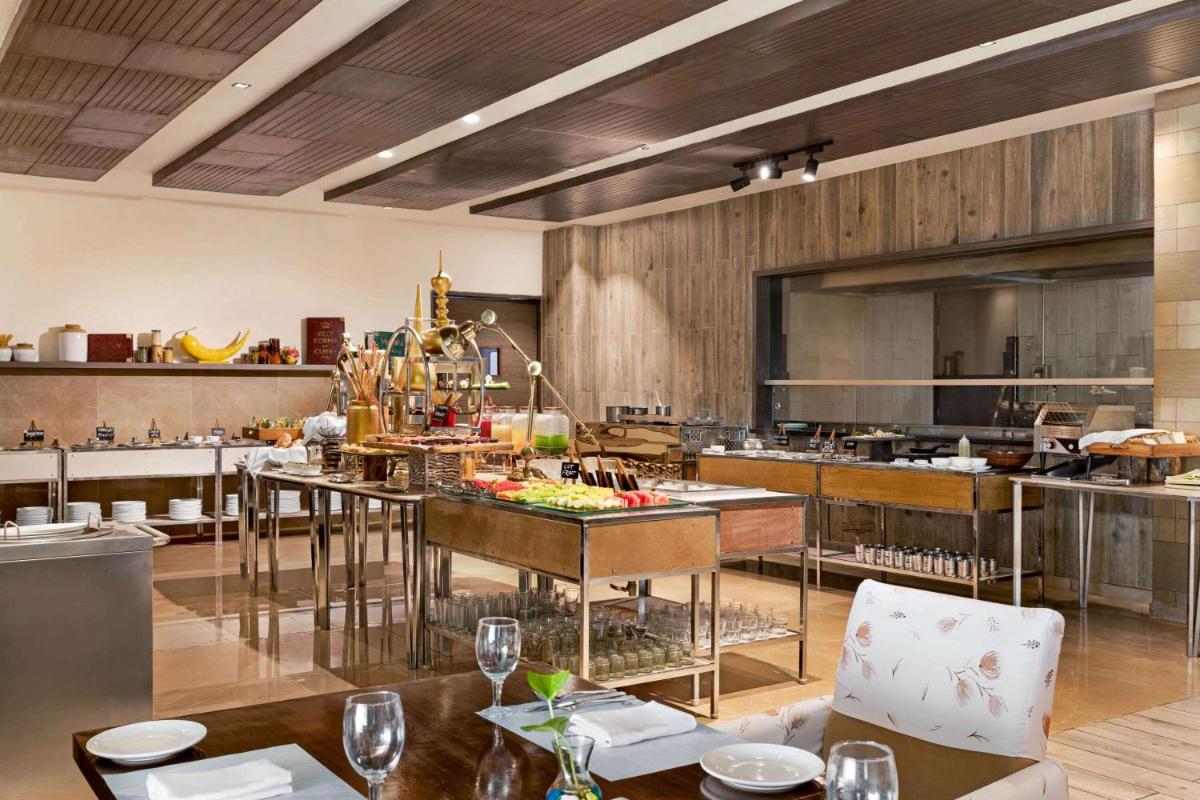 a large kitchen with a table in a restaurant at Wyndham Ahmedabad Shela in Ahmedabad