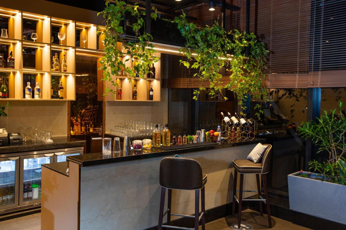 a bar in a restaurant with plants on the wall at Holiday Inn Bengaluru Racecourse by IHG in Bengaluru a bar in a restaurant with plants on the wall at Holiday Inn Bengaluru Racecourse by IHG in Bengaluru