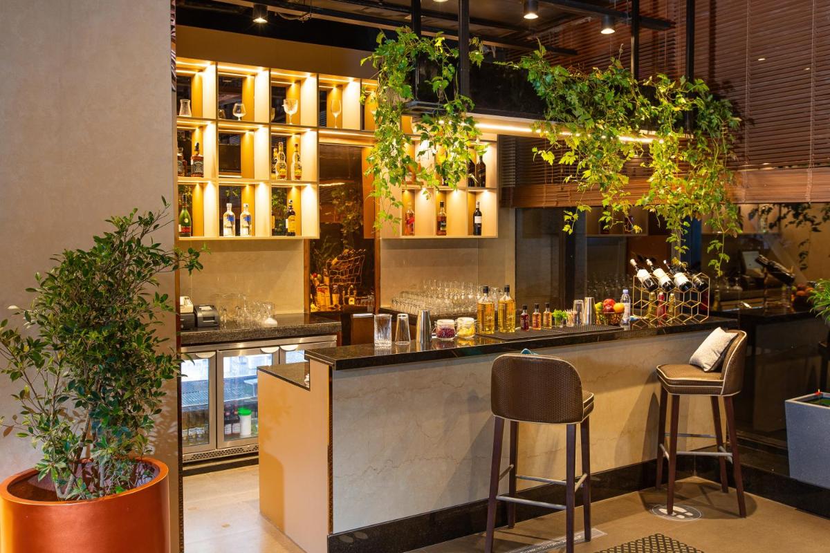 a bar in a restaurant with lots of plants at Holiday Inn Bengaluru Racecourse by IHG in Bengaluru a bar in a restaurant with lots of plants at Holiday Inn Bengaluru Racecourse by IHG in Bengaluru