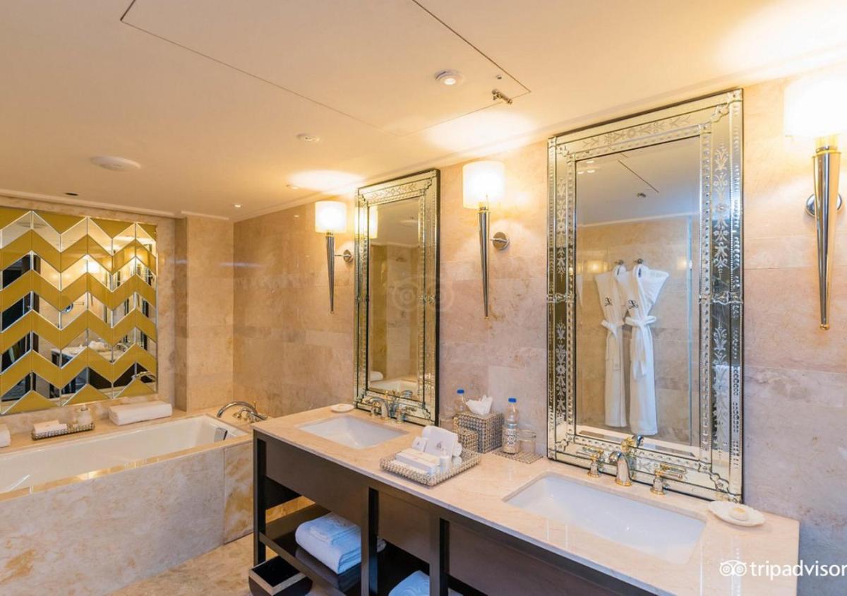 a large bathroom with two sinks and a tub and a tubermott at The Leela Palace Udaipur in Udaipur