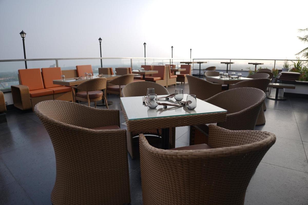a restaurant with tables and chairs on a roof at Crowne Plaza Kochi by IHG in Cochin