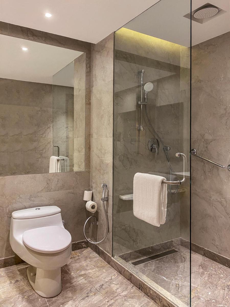 a bathroom with a toilet and a glass shower at Radisson Blu Hotel Amritsar in Amritsar