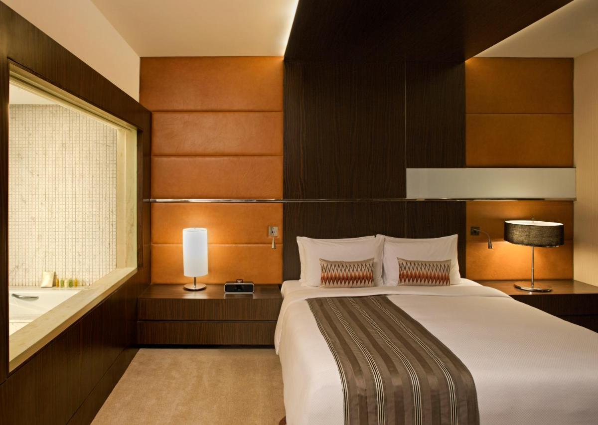 a bedroom with a bed and a sink and a window at Radisson Blu Hotel Amritsar in Amritsar