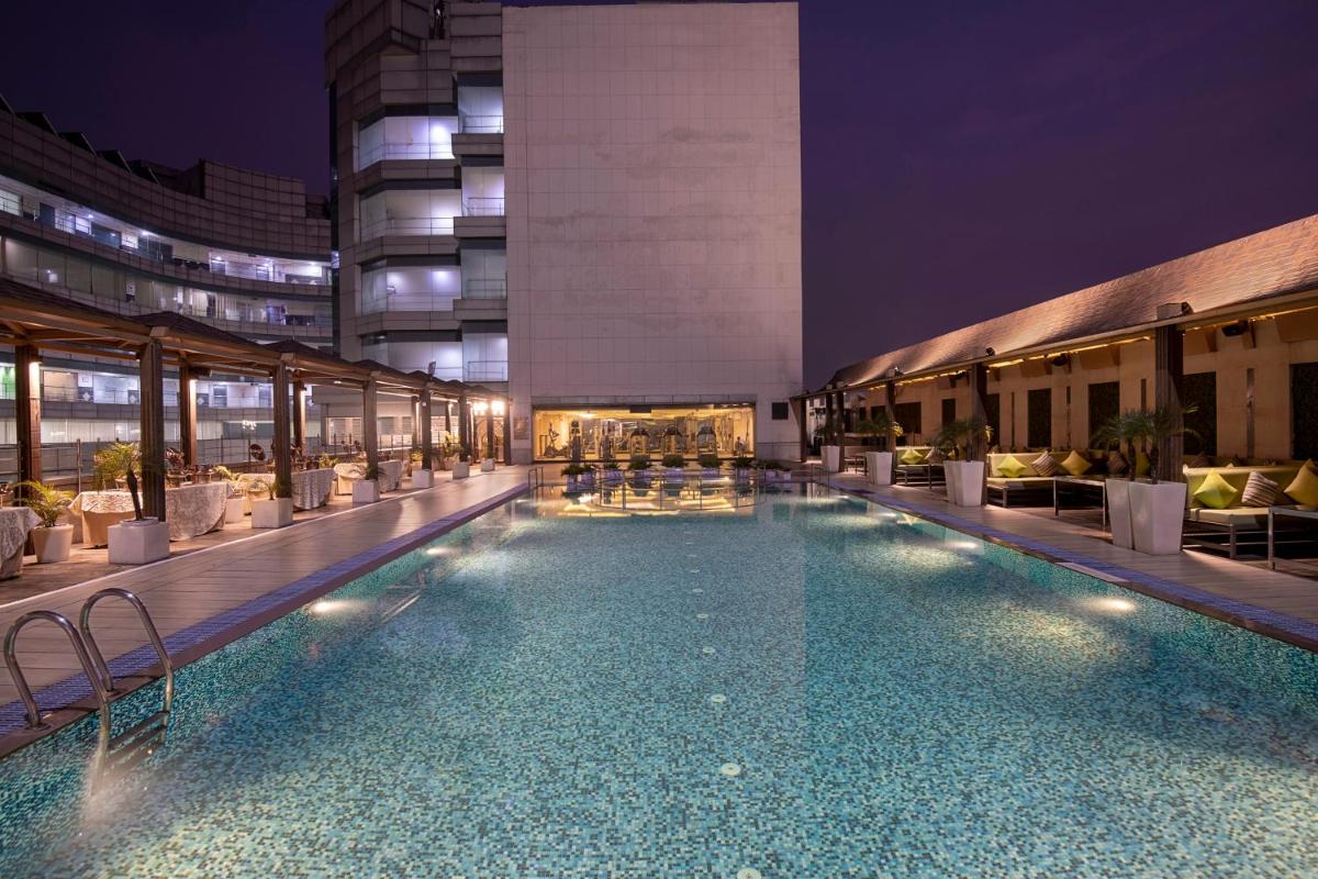 a large swimming pool in a building at night at Radisson Blu Kaushambi Delhi NCR in Ghaziabad