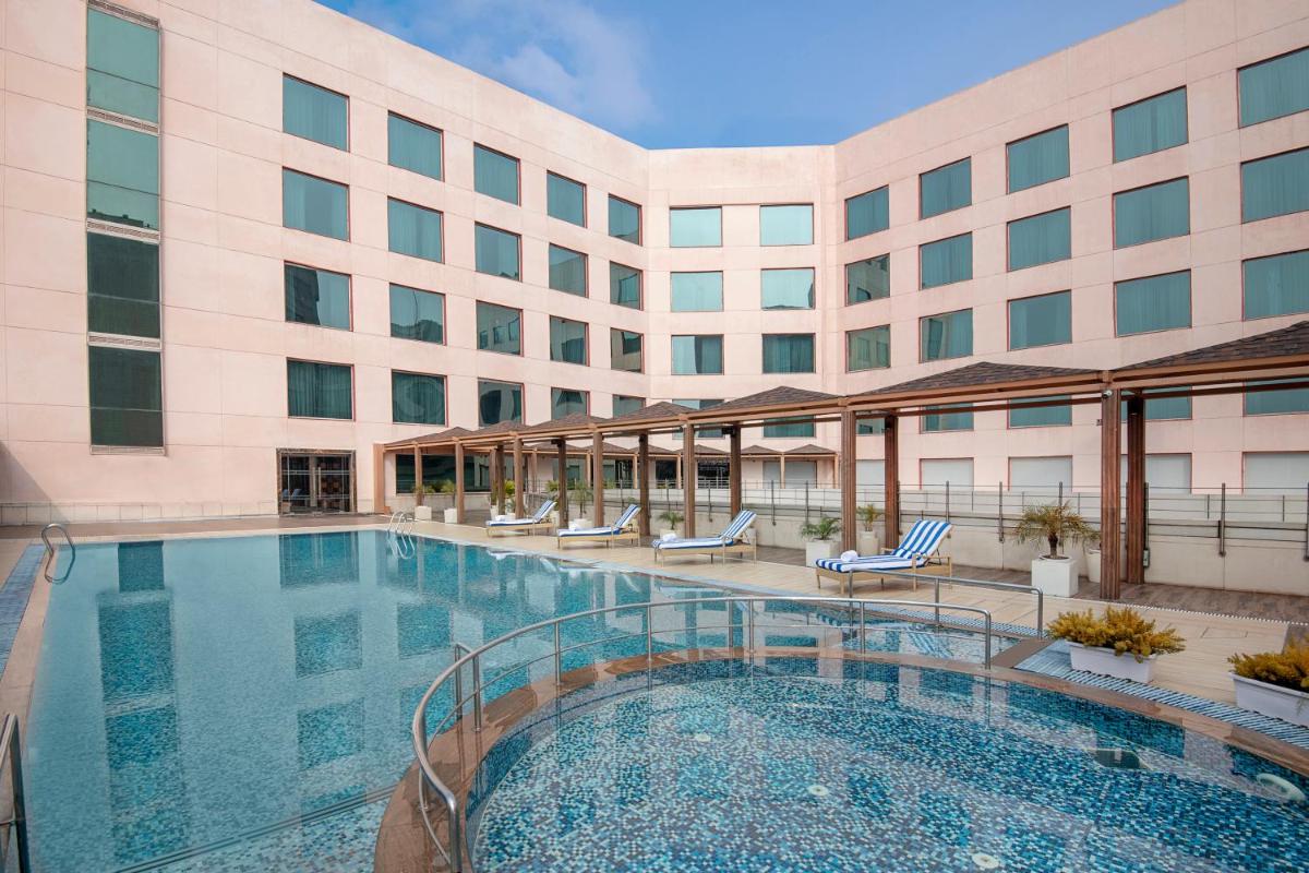a swimming pool in front of a hotel at Radisson Blu Kaushambi Delhi NCR in Ghaziabad