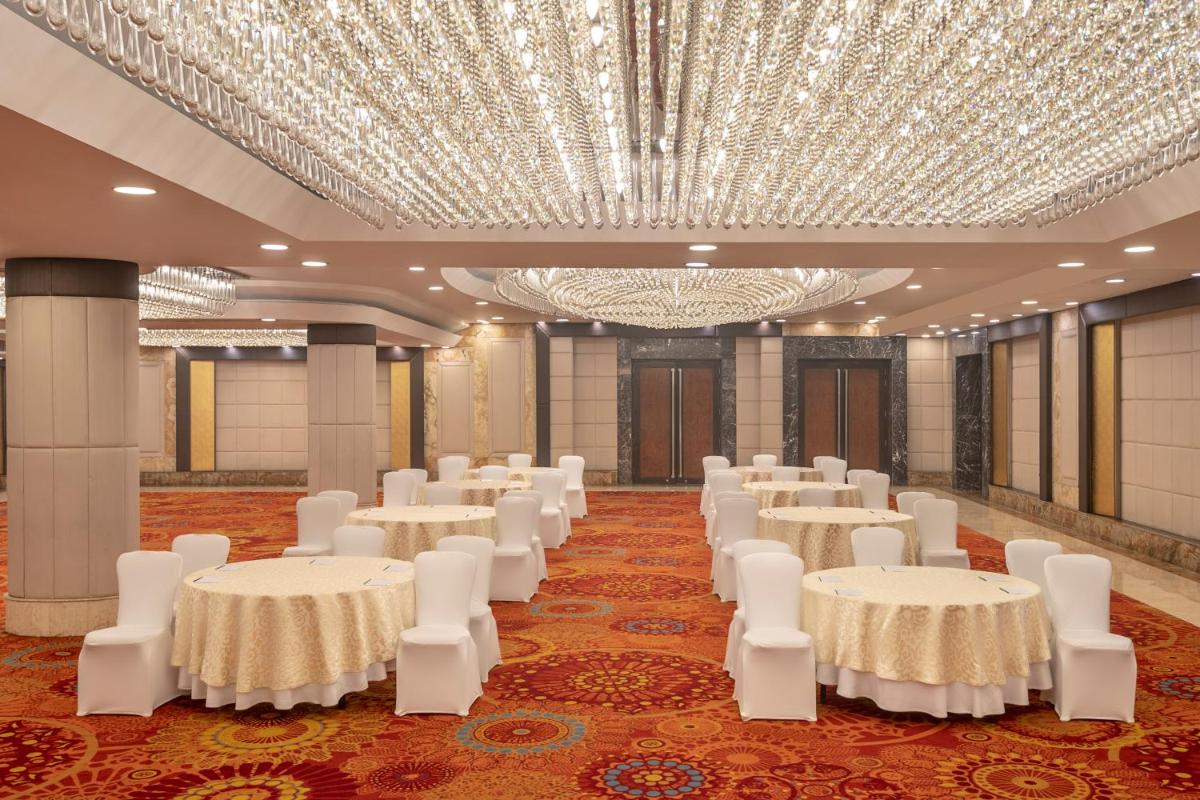 a banquet hall with white tables and white chairs at Radisson Blu Kaushambi Delhi NCR in Ghaziabad