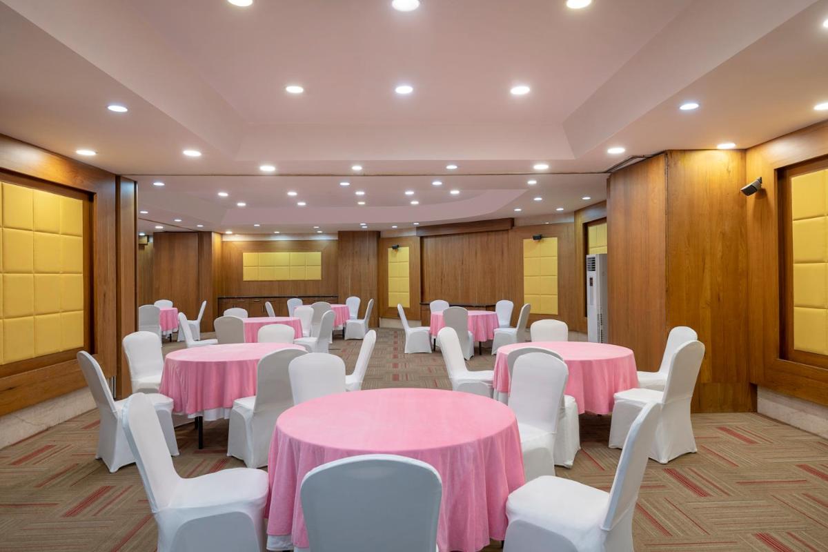 a room with pink and white tables and white chairs at Radisson Blu Kaushambi Delhi NCR in Ghaziabad