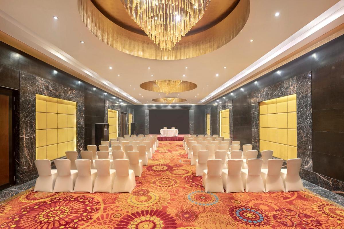 a row of chairs in a banquet hall with a chandelier at Radisson Blu Kaushambi Delhi NCR in Ghaziabad