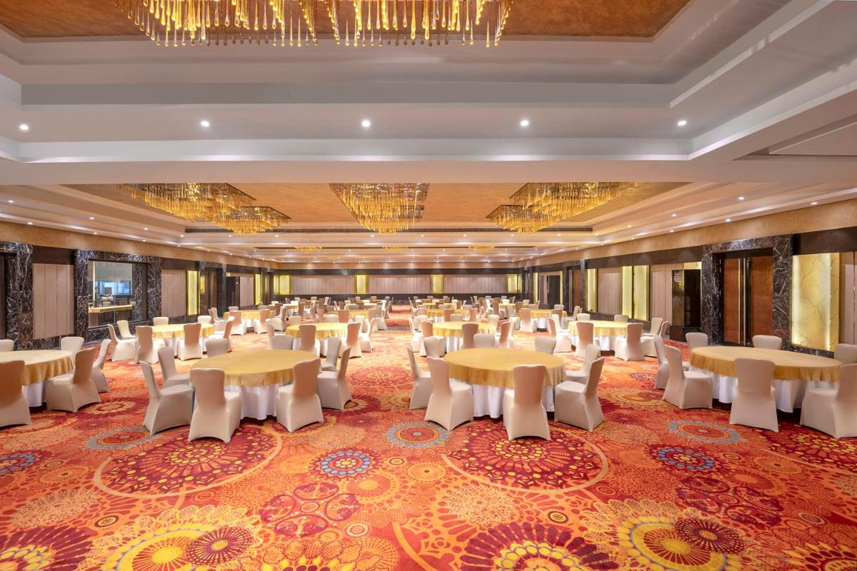 a large banquet hall with tables and chairs at Radisson Blu Kaushambi Delhi NCR in Ghaziabad
