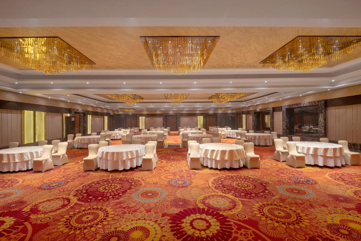 a banquet hall with white tables and white chairs at Radisson Blu Kaushambi Delhi NCR in Ghaziabad